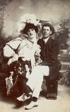Two men, one in drag, sit together on a bench, (between 1900 and 1901?). Creator: Unknown