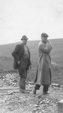 Two men standing near a small pile of rubble, in a field, between c1900 and 1916. Creator: Unknown