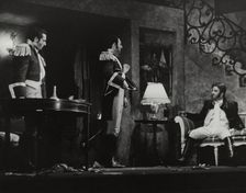 Two men standing, one sitting, 1938. Creator: Unknown