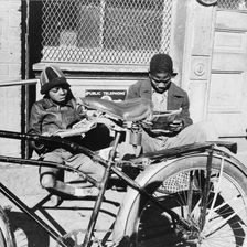 Two Negro boys reading the funnies on a doorstep, Washington, D.C., 1942. Creator: Gordon Parks