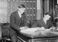 Two new citizens sign naturalizaton papers in judge's chambers, 1910. Creator: Bain News Service