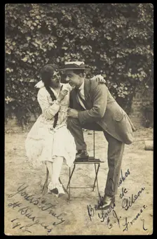 Two actors, one in drag, pose on garden furniture, 1918. Creator: Unknown