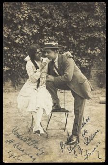 Two actors, one in drag, pose on garden furniture, 1918. Creator: Unknown