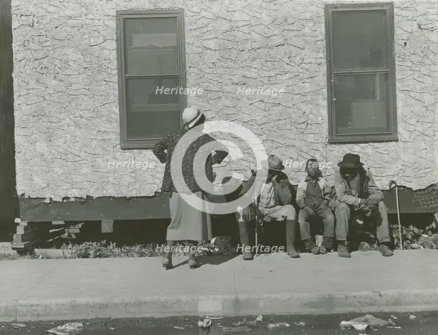 Two African American men and one African American boy sitting and one African..., Jan 1939. Creators: Farm Security Administration, Marion Post Wolcott.