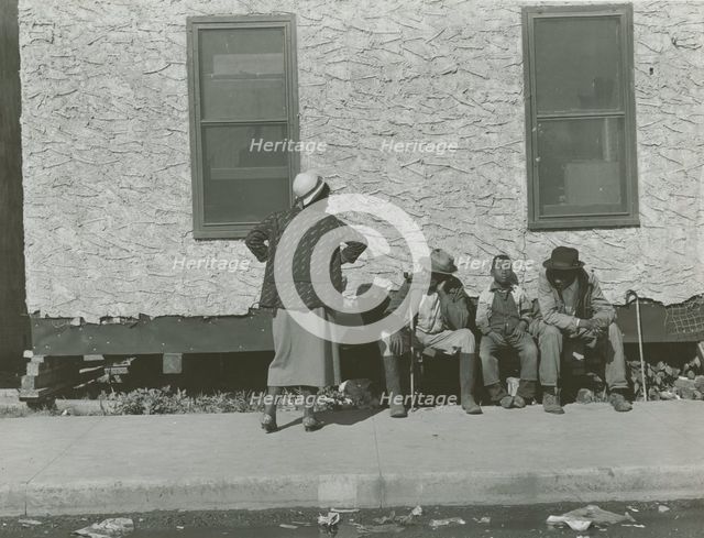 Two African American men and one African American boy sitting and one African..., Jan 1939. Creators: Farm Security Administration, Marion Post Wolcott.