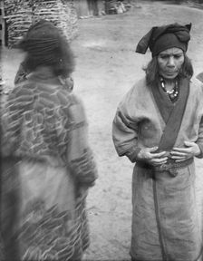 Two Ainu women in the village lane, 1908. Creator: Arnold Genthe