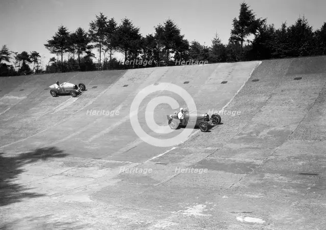 Two Bugatti Type 35s racing on the Members Banking at Brooklands. Artist: Bill Brunell.