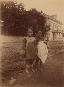 Two barefoot children standing in muddy street in front of the Lindholm's large..., (1899?). Creator: Eleanor Lord Pray