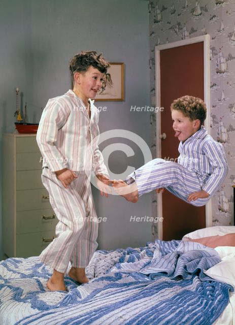 Two boys jumping on a bed, c1955.  Creator: Arthur Charles Kirby Ware.