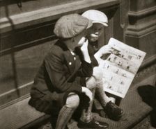 Two boys reading the comic section of the Sunday paper, New York, USA, 1931. Creator: Unknown
