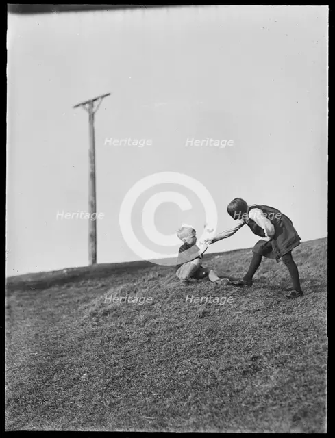 Two children playing in front of Combe Gibbet, Inkpen Hill, Inkpen, West Berkshire, 1925-1935. Creator: George R Long.