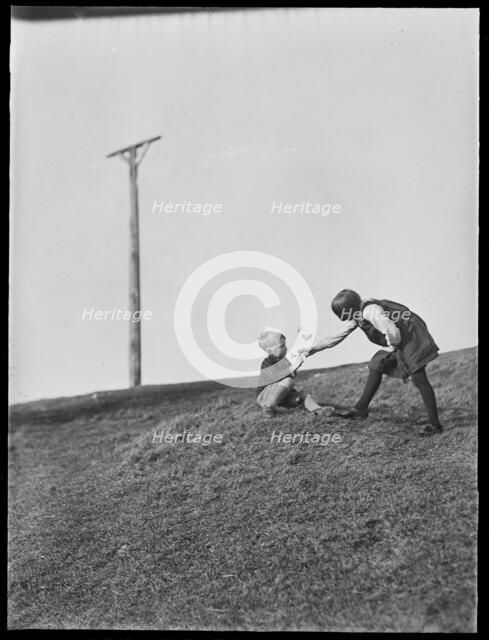Two children playing in front of Combe Gibbet, Inkpen Hill, Inkpen, West Berkshire, 1925-1935. Creator: George R Long.
