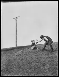 Two children playing in front of Combe Gibbet, Inkpen Hill, Inkpen, West Berkshire, 1925-1935. Creator: George R Long