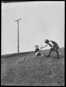 Two children playing in front of Combe Gibbet, Inkpen Hill, Inkpen, West Berkshire, 1925-1935. Creator: George R Long