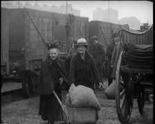 Two Elderly Female Civilians Wheeling a Barrow of Coal Away from a Railway Truck As Other..., 1924. Creator: British Pathe Ltd