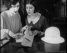 Two Female Civilians Cutting Sheets of Paper to Decorate a Hat, 1920. Creator: British Pathe Ltd