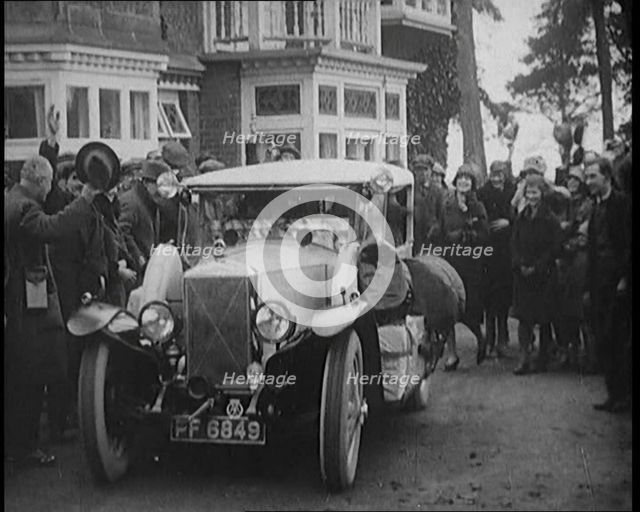 Two Female Civilians Explorers Driving Away in Their Heavily Loaded Car Watched by a Small..., 1920. Creator: British Pathe Ltd.