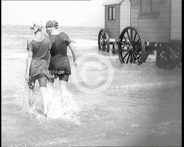 Two Female Civilians in Bathing Suits Walking Through Shallow Water Away from the Camera..., 1924. Creator: British Pathe Ltd.