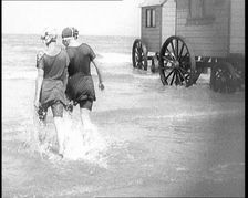 Two Female Civilians in Bathing Suits Walking Through Shallow Water Away from the Camera..., 1924. Creator: British Pathe Ltd