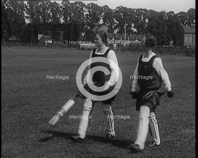 Two Female Civilians Wearing Gymslips and Batting Pads Holding Cricket Bats in a Playing Field, 1920 Creator: British Pathe Ltd.