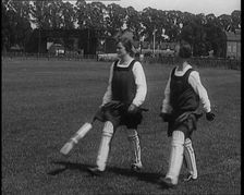 Two Female Civilians Wearing Gymslips and Batting Pads Holding Cricket Bats in a Playing Field, 1920 Creator: British Pathe Ltd