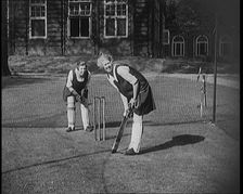 Two Female Civilians Wearing Gymslips and Batting Pads Preparing to Bat in a Playing Field, 1920. Creator: British Pathe Ltd