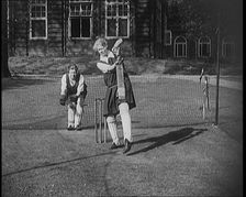 Two Female Civilians Wearing Gymslips and Batting Pads Preparing to Bat in a Playing Field, 1920. Creator: British Pathe Ltd