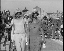 Two Female Civilians Wearing Smart Outfits Walking Towards the Camera in a Horse Race Event, 1920. Creator: British Pathe Ltd