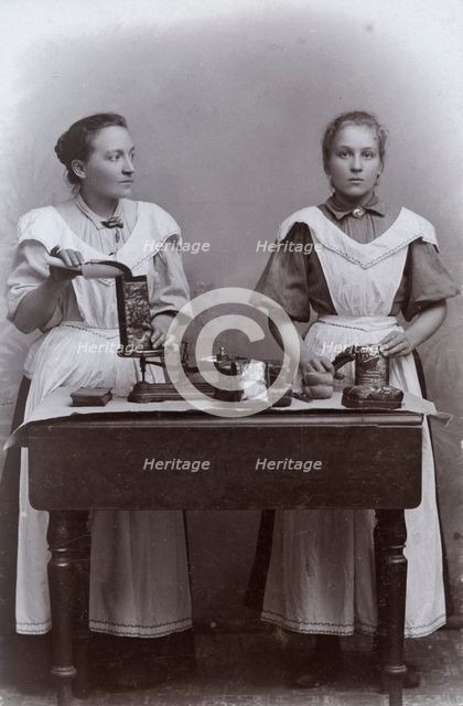 Two girls measuring coffee at the Dutch coffee shop, Landskrona, Sweden, 1910. Creator: Unknown.