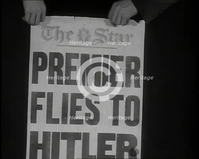 Two Hands Holding the Star Newspaper Headline 'PREMIER FLIES TO HITLER', 1938. Creator: British Pathe Ltd.