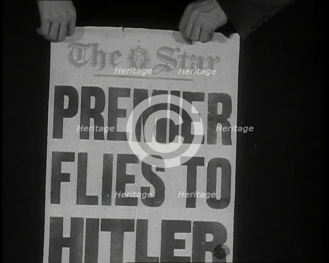 Two Hands Holding the Star Newspaper Headline 'PREMIER FLIES TO HITLER', 1938. Creator: British Pathe Ltd.