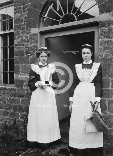 Two housemaids standing in the doorway of a house, Byfield, Northamptonshire, c1896-c1920. Artist: A Newton