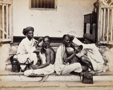 Two Indian barbers wearing turbans shaving the heads of two Indian men..., c1900s. Creator: Unknown