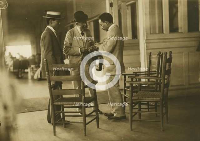 Two Japanese men and one American(?) man, probably journalists, conversing on the veranda..., 1905. Creator: Unknown.