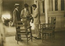 Two Japanese men and one American(?) man, probably journalists, conversing on the veranda..., 1905. Creator: Unknown