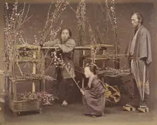 [Two Japanese Men and One Japanese Woman Posing with Flowering Branches], 1870s., Creator: Unknown
