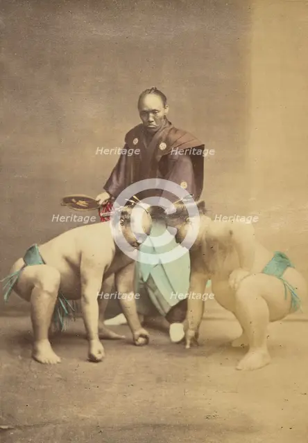 Two Japanese sumo wrestlers posed with referee, 1868-1880. Creator: Felice Beato.