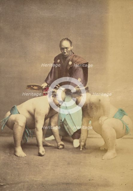 Two Japanese sumo wrestlers posed with referee, 1868-1880. Creator: Felice Beato.