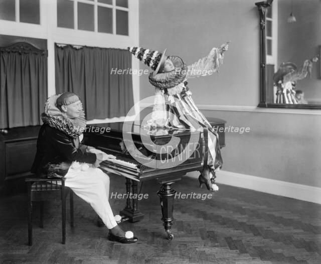 Two Pierrot clowns performing a routine with a piano, 1917. Artist: Bedford Lemere and Company.