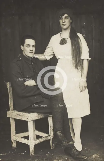 Two prisoners of war, one in drag, pose with a chair, [between 1910 and 1919?]. Creator: Unknown.
