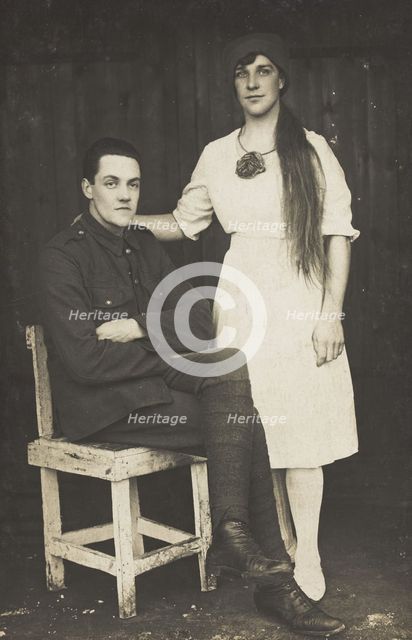 Two prisoners of war, one in drag, pose with a chair, [between 1910 and 1919?]. Creator: Unknown.