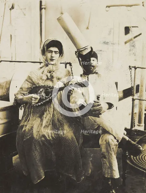 Two sailors (?) on board ship: one in drag is playing a guitar, 1907. Creator: Unknown.