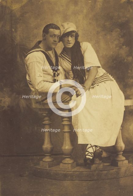 Two sailors, one in drag, embracing while sitting on a stage balcony, (between 1910 and 1919?). Creator: Unknown.