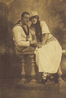 Two sailors, one in drag, embracing while sitting on a stage balcony, (between 1910 and 1919?). Creator: Unknown