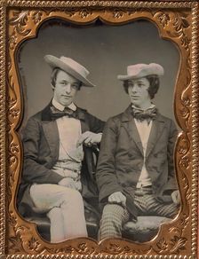 Two Seated Young Men Wearing Gingham Trousers, Bow Ties, and Brimmed, Soft Hats, 1850s. Creator: Unknown