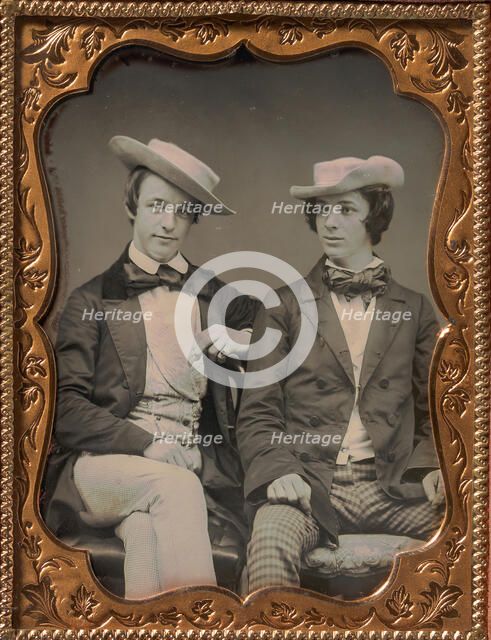 Two Seated Young Men Wearing Gingham Trousers, Bow Ties, and Brimmed, Soft Hats, 1850s. Creator: Unknown.