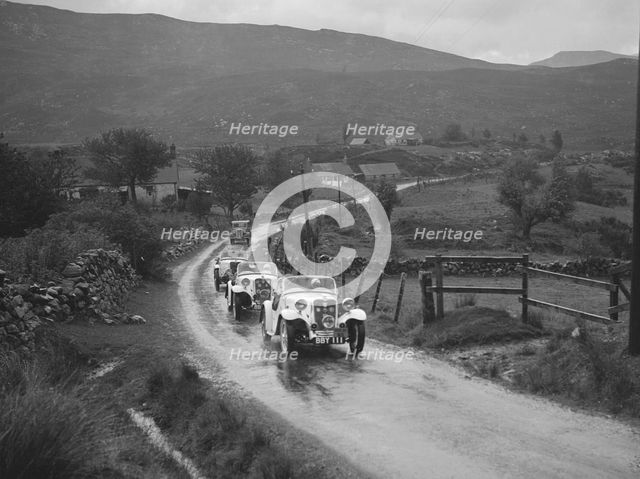 Two Singer Le Mans cars competing in the RSAC Scottish Rally, 1936. Artist: Bill Brunell.