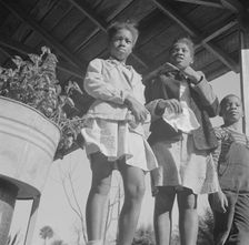 Two sisters with their brother on the front porch of the family home, Daytona Beach, Florida, 1943. Creator: Gordon Parks