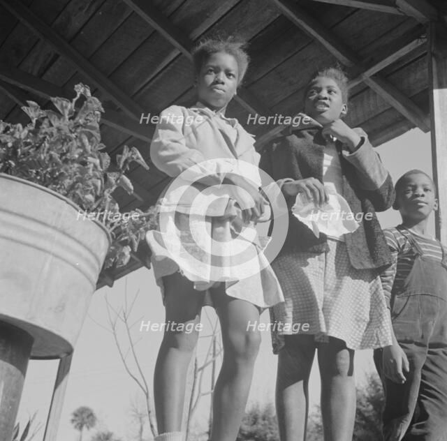 Two sisters with their brother on the front porch of the family home, Daytona Beach, Florida, 1943. Creator: Gordon Parks.