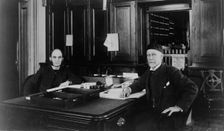 Two Treasury Department employees seated at desk in office, between 1884 and 1930. Creator: Frances Benjamin Johnston